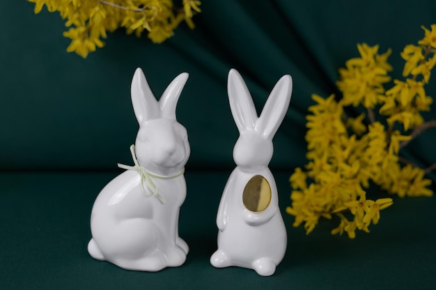 Gros lapins blancs sur fond vert et fleurs jaunes Carte de Joyeuses Pâques Concept