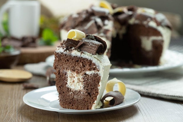 Gros morceau de gâteau au chocolat blanc et au chocolat noir deux amours sur table en bois Gâteau d'anniversaire et de mariage