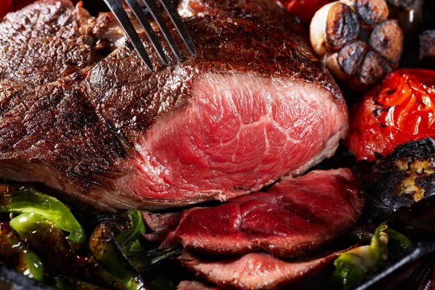 Gros morceau de viande grillée avec des légumes en gros plan