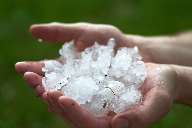 Gros morceaux de glace grêle dans la paume de votre main