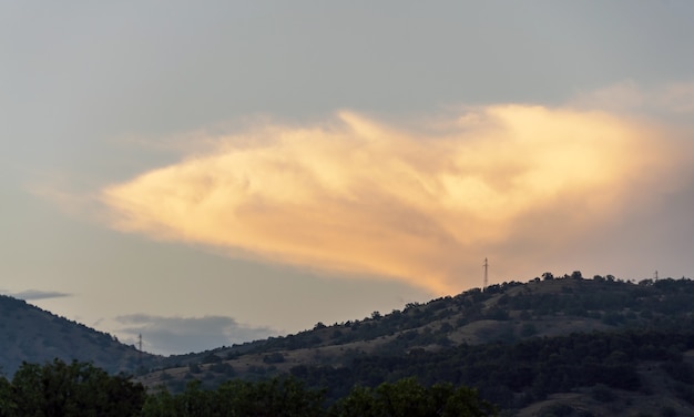 Un gros nuage au coucher du soleil sur les montagnes. Crimée. Choban-kule.