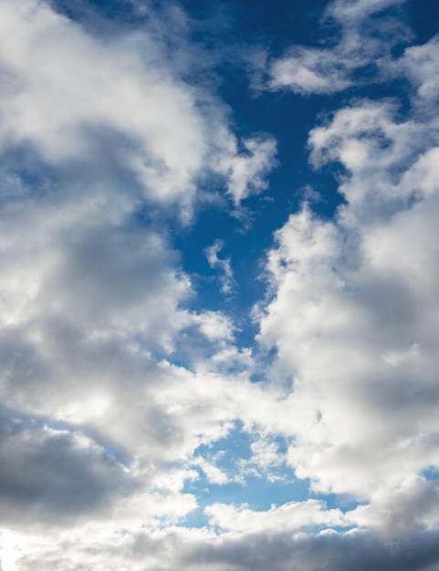 Gros nuages blancs duveteux dans le ciel bleu par temps ensoleillé, format vertical