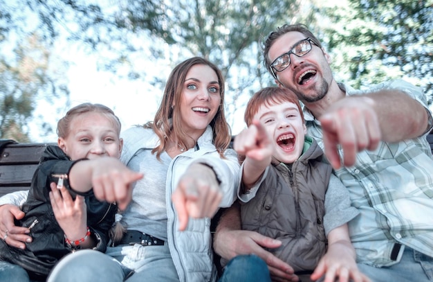 Gros parents avec deux enfants pointant vers vous le concept de loisirs familiaux