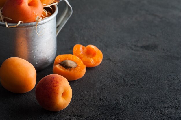 Gros plan d'abricots frais dans une tasse en étain