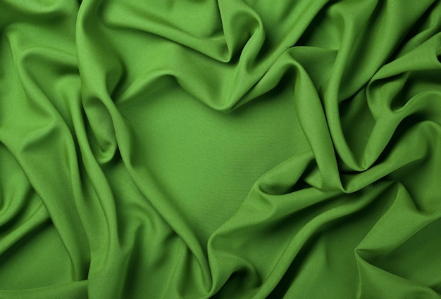 Gros plan abstrait textile de plis de tissu vert en forme de coeur, vue de dessus surélevée, directement au-dessus