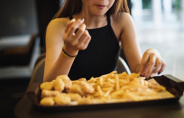 Gros plan d&#39;une adolescente manger le concept de l&#39;obésité de frites français