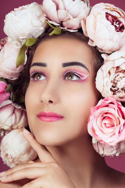 Un gros plan d'une adolescente portant des fleurs