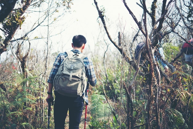 Gros plan d&#39;amis marchant avec des sacs à dos en bois depuis le dos.