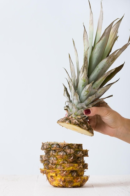 Gros plan de l'ananas coupé sur une table en bois blanc et sur fond bleu clair