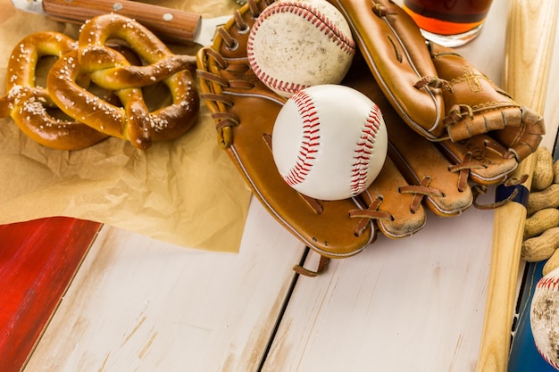 Gros plan de l'ancien équipement de baseball usé sur un fond en bois.