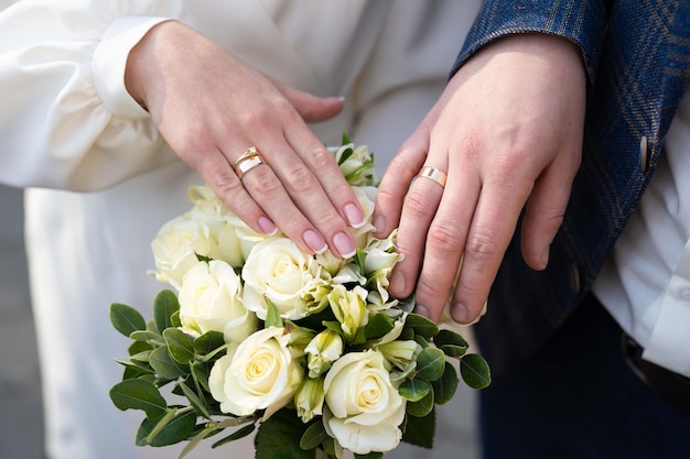 Gros plan des anneaux de mariage sur les mains de la mariée et du marié un couple amoureux main dans la main ensemble