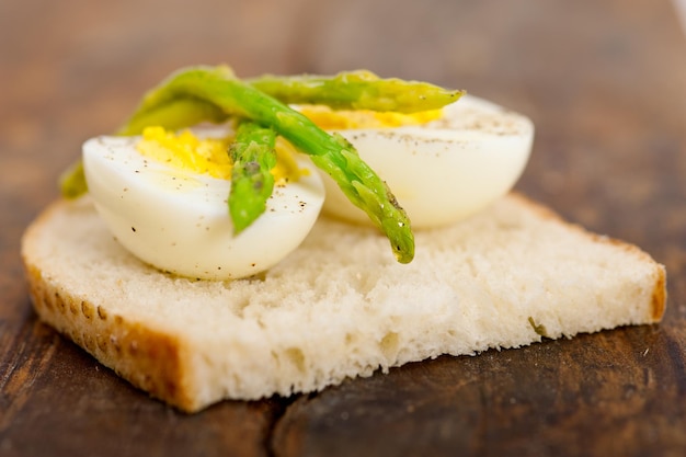 Photo en gros plan des asperges et des œufs bouillis sur du pain