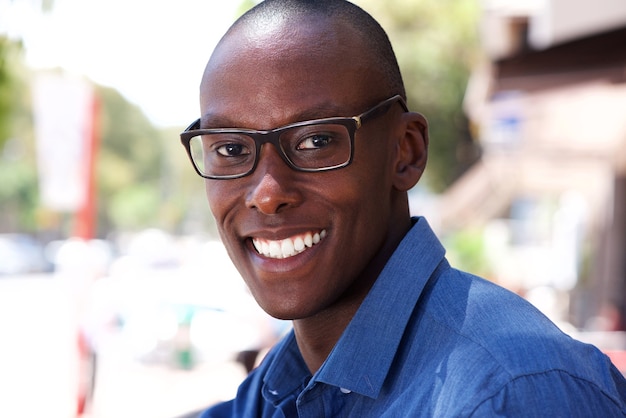 Gros plan attrayant jeune homme noir avec des lunettes