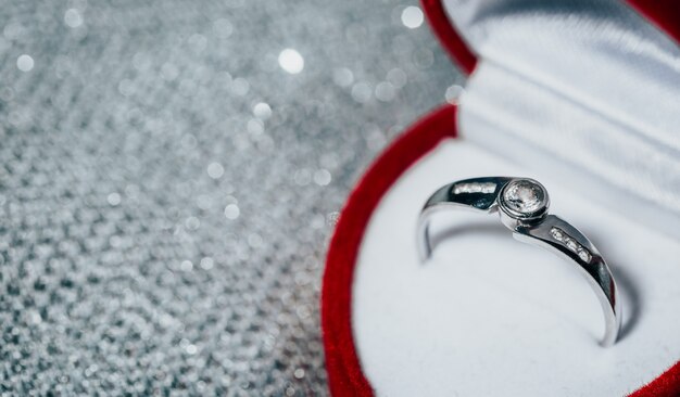 Gros plan d'une bague de fiançailles en or blanc avec diamants dans la boîte rouge, concept d'amour