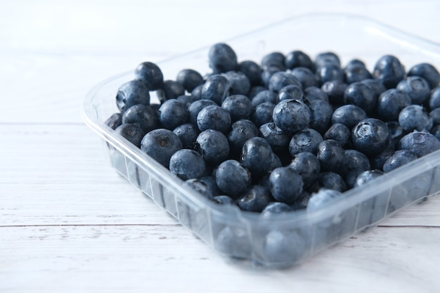 Gros plan de baies bleues fraîches dans un récipient en plastique sur la table