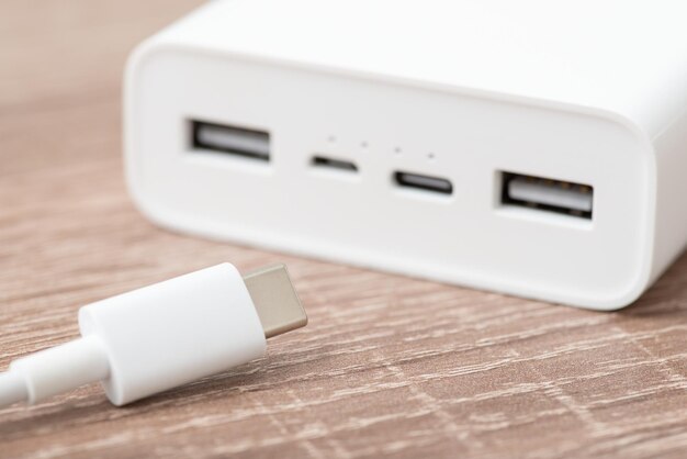 Gros plan d'une banque d'alimentation avec câble usb typec au premier plan Utilisation d'une banque d'alimentation pour charger des appareils