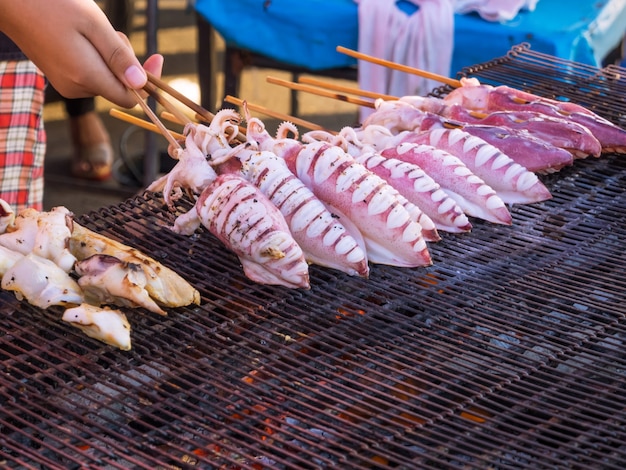 Gros plan barbecue de calmar frais grillé sur un réchaud à charbon