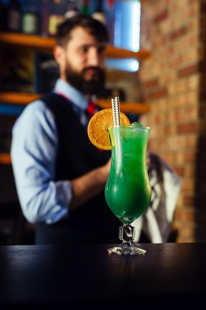 Photo gros plan sur un barman décorant un cocktail lagon bleu