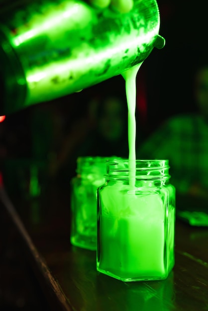 Gros plan d'un barman versant un cocktail alcoolisé dans un verre Feu vert Reste dans un bar-restaurant de discothèque