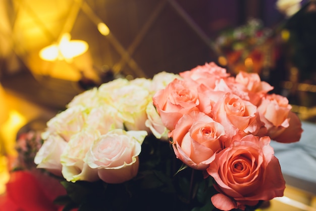 Gros plan d'un beau bouquet de roses aux couleurs douces. Fond de Bockeh, restaurant chez les sourds. Faible profondeur de champ. Fleur de concept pour vous.