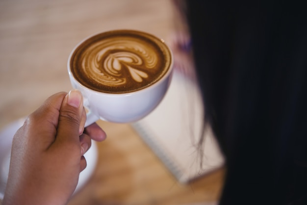 Gros plan, beau, femme, écriture, cahier, à, café, tasse