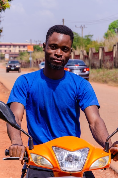 Photo gros plan d'un beau jeune motocycliste africain