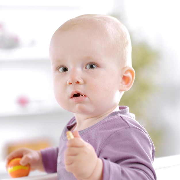 Gros plan bébé mignon mangeant un cookie assis sur le canapé