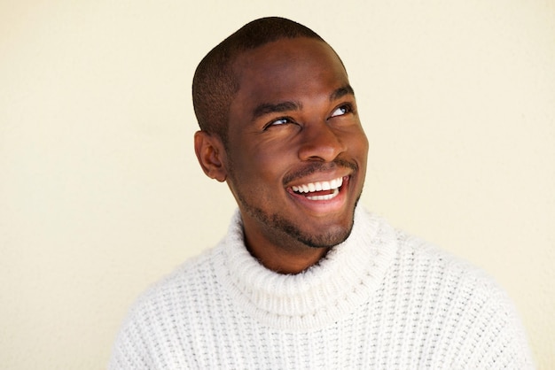 Gros plan bel homme afro-américain pensant et regardant loin en souriant