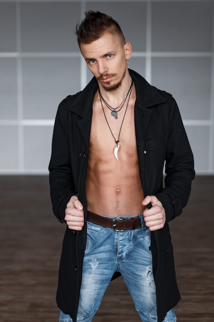 Gros plan sur bel homme sexy en manteau noir