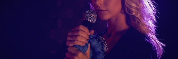 Gros plan d'une belle chanteuse avec microphone