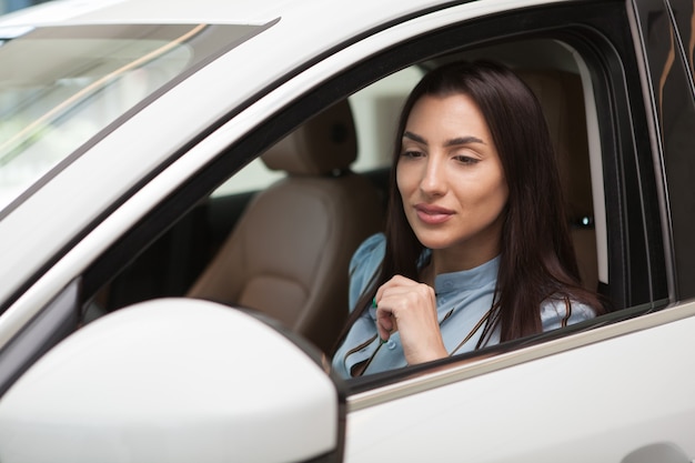 Gros plan d'une belle conductrice assise dans une voiture