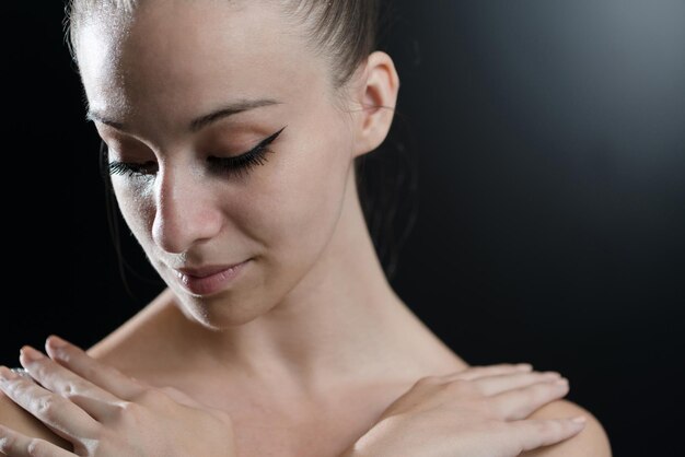 Gros plan d'une belle danseuse de ballet féminine sur fond noir