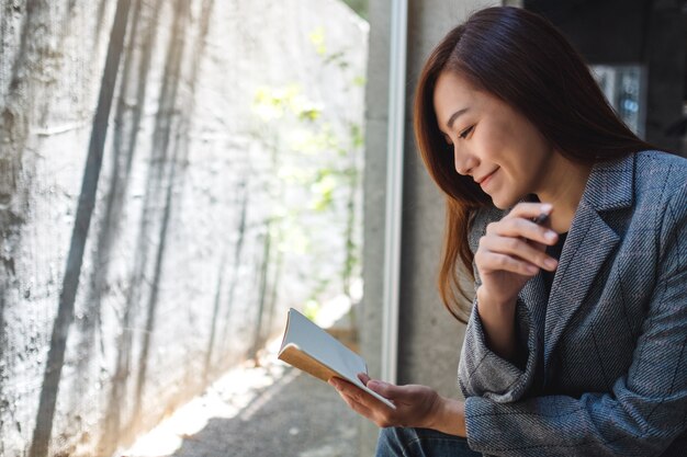 Gros plan d'une belle femme d'affaires asiatique tenant et regardant un ordinateur portable