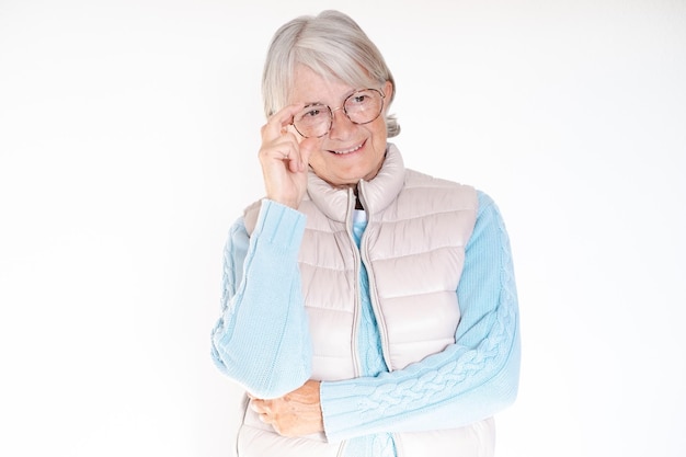 Gros plan sur une belle femme âgée aux cheveux blancs touchant des lunettes avec les mains semble confiante