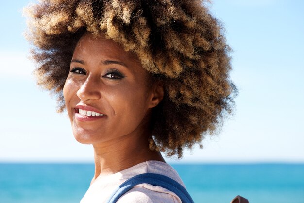 Gros plan belle femme américaine afro avec des cheveux bouclés debout à l&#39;extérieur