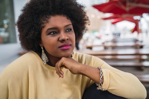 Gros plan d'une belle femme latine afro-américaine assise au café.