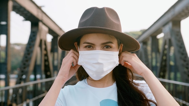 Gros plan belle femme porte un masque chirurgical sur le pont