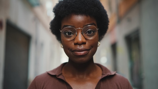 Gros plan belle fille africaine dans des verres regardant la caméra