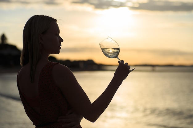 Gros plan de la belle jeune femme buvant du vin blanc