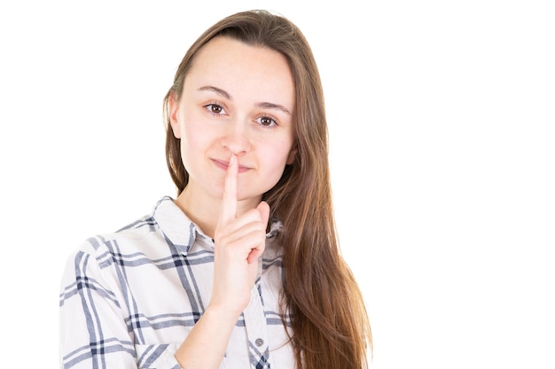 Gros plan d'une belle jeune femme avec le doigt sur ses lèvres sur fond blanc dans Concept pour le silence