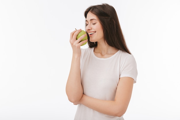 Gros plan d'une belle jeune femme heureuse isolée, montrant la pomme verte
