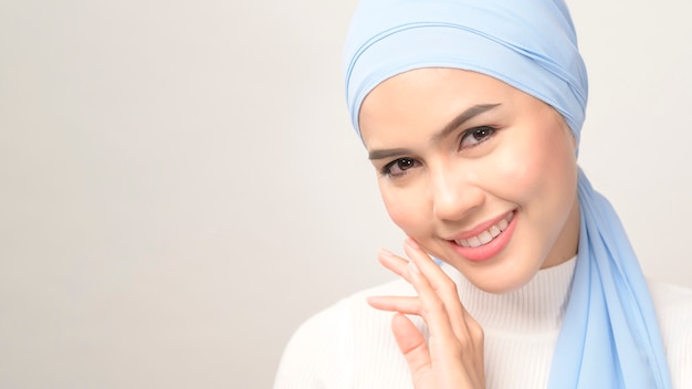 Un gros plan de la belle jeune femme musulmane avec hijab isolé sur fond blanc studio, concept de soins de la peau beauté musulmane.