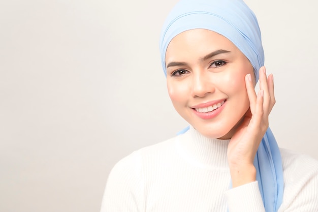 Un gros plan de la belle jeune femme musulmane avec hijab isolé sur fond blanc studio, concept de soins de la peau beauté musulmane.