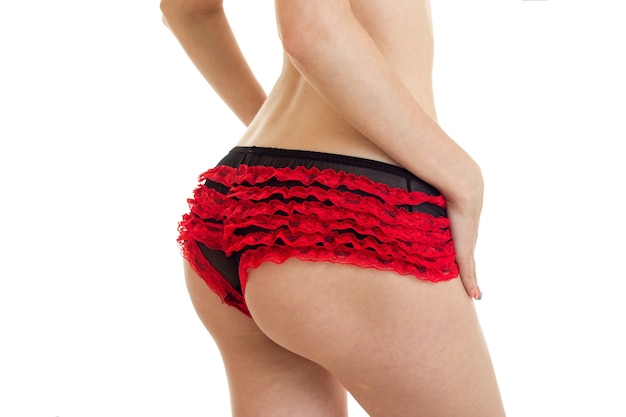 Photo gros plan de belles fesses rondes féminines en rouge avec une culotte noire isolée sur fond blanc