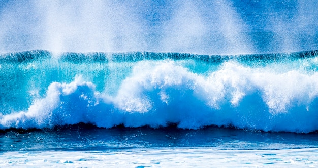 Gros plan sur de belles et grandes vagues bleues et vertes se brisant - océan pacifique ou athlétique - mer bleue et endroit idéal pour surfer