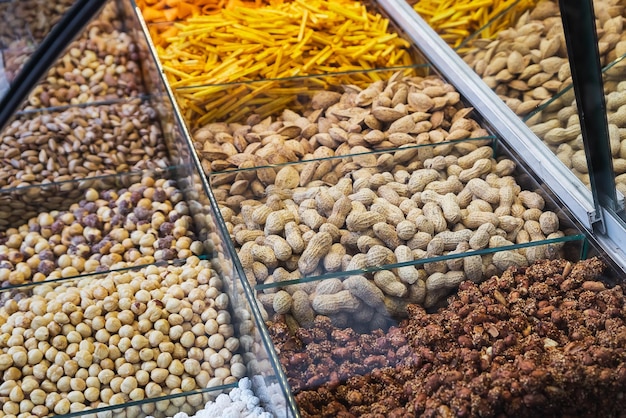 Gros plan de belles rangées de noix fraîches noisettes décortiquées noix de cajou figues amandes diverses noix sur la vitrine du marché