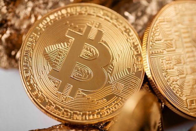 Gros Plan De Bitcoin D'or Comme Principale Crypto-monnaie Avec Des Morceaux D'or Floues Sur Le Fond.