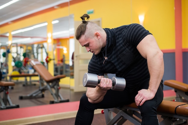 Gros plan d'un bodybuilder travaillant au gymnase