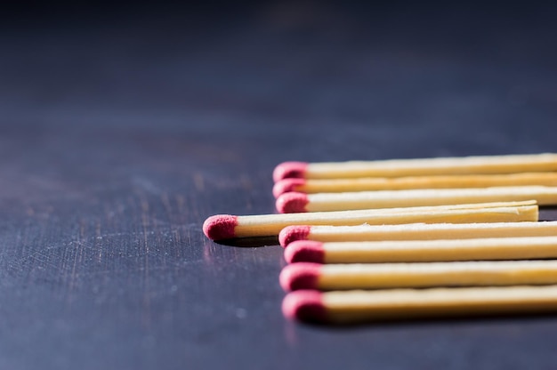 Gros plan de boîtes d'allumettes isolées sur fond sombre correspond à une boîte d'allumettes sur une table en bois