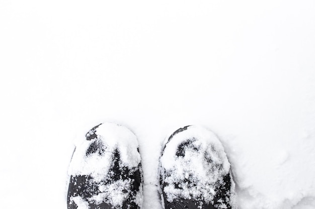 Gros plan de bottes de randonnée dans le fond d'hiver de neige